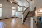 This three-story property on Pujol Street in Temecula, California offers a well-designed layout spread across multiple levels. The main living area immediately impresses with soaring ceilings, light hardwood flooring, and an open staircase featuring dark wood handrails and carpeted treads, complemented by a ceiling fan overhead. Multiple windows allow natural light to flow throughout, creating a bright and welcoming ambiance. An upper-level landing with metal balusters overlooks the living space below, reinforcing the home's open, airy character.

The kitchen is equipped with light maple cabinetry, tile backsplash, hardwood flooring, and stainless steel appliances including a refrigerator, gas range, and built-in microwave. A dedicated laundry area houses a full-size washer and dryer set with overhead shelving for added storage.

The bedrooms feature plush carpeting, ceiling fans, and windows overlooking the surrounding greenery. Bathrooms include tile flooring, a tub-shower combination with stone-tiled surround, and maple vanity cabinetry with countertops. A powder room provides additional convenience. The spacious garage spans a generous footprint with a concrete floor, windows for natural light, and an automatic opener system.
