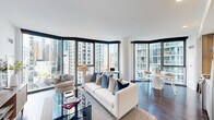Located at 455 East Waterside Drive in Chicago's vibrant Streeterville neighborhood, this well-appointed 2-bedroom, 2-bathroom residence offers a thoughtfully designed single-floor layout with modern finishes and impressive urban views. A welcoming hallway with dark hardwood flooring leads into the open-concept living, dining, and kitchen area, which serves as the heart of the home. Corner floor-to-ceiling windows flood the living space with natural light and frame sweeping Chicago skyline views, creating a bright and airy atmosphere. The living area features dark hardwood floors and a seamless flow into the dining space, ideal for both relaxing and entertaining. The primary bedroom includes a bold teal accent wall, hardwood flooring, and generous closet space, while the second bedroom benefits from its own floor-to-ceiling window with city views. Three closets provide ample storage throughout the unit. The two bathrooms are finished in a clean, contemporary style — one featuring a soaking tub and shower combination with light wood cabinetry, and the other a sleek glass-enclosed walk-in shower with white tile surround. An in-unit laundry area adds everyday convenience. The overall ambiance is modern, bright, and polished, well-suited for urban living in one of Chicago's most sought-after locations.