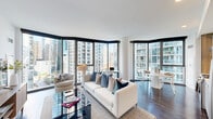 Located at 455 East Waterside Drive in Chicago's vibrant Streeterville neighborhood, this well-appointed 2-bedroom, 2-bathroom residence offers a thoughtfully designed single-floor layout with modern finishes and impressive urban views. A welcoming hallway with dark hardwood flooring leads into the open-concept living, dining, and kitchen area, which serves as the heart of the home. Corner floor-to-ceiling windows flood the living space with natural light and frame sweeping Chicago skyline views, creating a bright and airy atmosphere. The living area features dark hardwood floors and a seamless flow into the dining space, ideal for both relaxing and entertaining. The primary bedroom includes a bold teal accent wall, hardwood flooring, and generous closet space, while the second bedroom benefits from its own floor-to-ceiling window with city views. Three closets provide ample storage throughout the unit. The two bathrooms are finished in a clean, contemporary style — one featuring a soaking tub and shower combination with light wood cabinetry, and the other a sleek glass-enclosed walk-in shower with white tile surround. An in-unit laundry area adds everyday convenience. The overall ambiance is modern, bright, and polished, well-suited for urban living in one of Chicago's most sought-after locations.