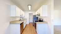 This 790 square foot apartment offers a thoughtfully designed living space with two bedrooms and one bathroom. The interior showcases a blend of modern amenities and practical features. The kitchen, a focal point of the home, boasts crisp white cabinetry, stainless steel appliances, and a sleek countertop, creating an inviting cooking environment. The bathroom is equally impressive, featuring a contemporary vanity, large mirror, and a shower/tub combination with stylish fixtures.

The living areas are characterized by their versatile flooring choices. The kitchen and bathroom feature durable wood-look flooring, while the bedrooms are outfitted with plush carpeting, adding warmth and comfort. Large windows in the living room and bedrooms allow natural light to flood the space, creating an open and airy atmosphere. The primary bedroom, measuring 160 square feet, offers ample space for relaxation.

Storage solutions are integrated throughout, with built-in closets in the bedrooms and additional cabinet space in the kitchen. The apartment's layout maximizes the available space, ensuring a comfortable flow between rooms. A sliding glass door in the living area leads to an outdoor space, extending the living area and providing a connection to the surrounding environment. Overall, this apartment combines functionality with modern aesthetics, offering a cozy yet contemporary living experience.