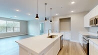 Located at 2901 Corporate Exchange Dr in Columbus, Ohio, this well-appointed 2-bedroom, 2-bathroom single-floor residence offers a thoughtfully designed layout with modern finishes throughout. The open-concept kitchen and living area serves as the heart of the home, featuring a large center island with pendant lighting, crisp white shaker cabinetry, light quartz countertops, and a full suite of stainless steel appliances including a range, microwave, and French door refrigerator. Light hardwood-style flooring flows throughout the main living areas, complementing the neutral, warm-toned walls. The primary bedroom is generously sized, complete with a ceiling fan, wide window with blinds offering natural light, and access to an en-suite bathroom. The primary bath includes a dual-sink vanity with white cabinetry, a large mirror, and a glass-enclosed shower. The second bedroom also features soft carpeting, a ceiling fan, and natural light from a window with blinds. The second full bathroom offers a single-sink vanity and a tub-shower combination. Both bedrooms are served by walk-in closets with wire shelving systems. A dedicated in-unit laundry room houses a full-size washer and dryer. The layout is completed by two hallways connecting all areas of the residence seamlessly.