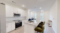 Located at 2652 S Main St NW in Kennesaw, GA, this well-designed one-bedroom, one-bathroom unit offers a thoughtful layout that maximizes its footprint. The open-concept kitchen and living area serves as the heart of the home, anchored by a large granite-topped island with bar seating — ideal for casual dining or entertaining. The kitchen is outfitted with white shaker cabinetry, a subway tile backsplash, and stainless steel appliances including a refrigerator with ice maker, range, and microwave. Light hardwood-style flooring runs throughout the main living areas, complementing the bright, white walls and recessed lighting overhead. The living room benefits from natural light streaming through multiple windows and a glass door that opens to a small outdoor area. The spacious bedroom features soft carpet flooring, a ceiling fan, and a window for additional natural light. A dedicated closet area includes a stacked washer and dryer, adding everyday convenience. The bathroom is finished with a granite vanity, white subway tile tub surround, and light wood-style flooring, maintaining the clean, modern aesthetic found throughout the unit. This home offers a cohesive, contemporary design with quality finishes throughout.