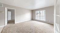 Located at 6233 Gulfton St in Houston, TX, this single-story, three-bedroom, two-bathroom home offers a functional and straightforward layout across its well-utilized floor plan. The living area features neutral-toned carpet and a built-in bookshelf, flowing seamlessly into a dining space accented by a chandelier and tile flooring. The kitchen is appointed with gray cabinetry, dark granite countertops, a decorative stone tile backsplash, and stainless steel appliances, providing a practical and stylish space for cooking and entertaining. The spacious primary bedroom includes a generously sized walk-in closet with dual hanging rods, offering ample storage. Two additional bedrooms are finished with soft carpet, ceiling fans, and natural light from blinds-covered windows; one features its own closet with built-in shelving. Both bathrooms are fitted with tiled tub-shower combinations and tile flooring. One bathroom includes a granite-topped vanity, while the second offers a clean, minimalist design. Throughout the home, neutral wall tones and white trim create a cohesive, light aesthetic, making each room feel open and move-in ready.