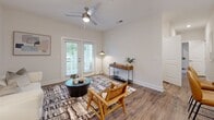 Located at 338 Battery Park Circle in Pendleton, South Carolina, this single-story residence offers two bedrooms and two bathrooms within a thoughtfully designed floor plan. The interior showcases a cohesive, contemporary aesthetic with neutral tones, wood-look flooring, and plush carpet in the bedrooms.

The living room serves as the heart of the home, featuring hardwood-style flooring, a ceiling fan, and French doors that invite natural light and outdoor views. It flows naturally into the dining area, which is accented by warm wood-look floors and a pendant light fixture. The kitchen is well-equipped with granite countertops, dark shaker-style cabinetry, stainless steel appliances, a deep undermount sink, and pendant lighting — all contributing to a polished, functional space.

The primary bedroom is generously sized, featuring carpet flooring, a ceiling fan, and large windows offering outdoor views. Both bedrooms include walk-in closets outfitted with wire shelving systems for organized storage. The bathrooms feature granite-topped vanities and tiled tub-shower combinations with wood-look flooring. A dedicated utility room rounds out the layout, adding practical convenience to this well-designed residence.