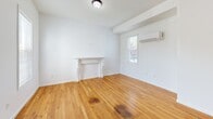 Located at 48 High St in Bristol, CT, this 2-bedroom, 1-bathroom unit offers a well-organized single-floor layout with a clean, updated aesthetic throughout. Warm hardwood flooring flows continuously across the living areas and bedrooms, lending a cohesive feel to the space.

The living room is a standout, featuring a classic decorative fireplace with a white painted mantle, a wall-mounted mini-split air conditioning unit, and a window that brings in natural light with outdoor views. The open sight lines and elevated ceiling height add to the sense of spaciousness.

The kitchen is well-appointed with rich dark-wood cabinetry extending to the ceiling, light granite countertops, and a full suite of stainless steel appliances including a refrigerator, range, microwave, and dishwasher. A stainless steel sink with a modern faucet completes the functional layout.

The primary bedroom is generously sized, boasting vaulted ceilings and a double-door closet, while the second bedroom features dual windows that provide ample natural light and exterior views. The full bathroom is finished with tile flooring, a granite-topped vanity with dark wood cabinetry, a soaking tub, and a large mirror with overhead lighting.