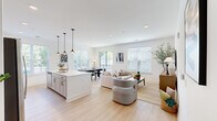 This single-floor residence at 1009 Reagans Rd in Frederick, Maryland offers a thoughtfully designed open-concept layout that seamlessly connects the kitchen, dining, and living areas into one bright, cohesive space. Light hardwood flooring flows throughout, complementing the clean white walls and recessed lighting that give the home a fresh, modern feel.

The kitchen is a standout feature, boasting white shaker cabinetry with matte black hardware, a large center island with pendant lighting, and crisp white quartz countertops. Ample storage and a dedicated pantry area add to the kitchen's functionality. The dining area sits adjacent to a sliding glass door leading to an outdoor balcony, filling the space with natural light and garden views.

The living area is generously sized, with multiple windows fitted with white blinds that allow for both brightness and privacy. A secondary sitting room provides flexible living space.

The bedrooms are calm and well-proportioned, each with large windows and hardwood flooring. The primary bedroom includes a walk-in closet outfitted with wire shelving systems for organized storage. The primary bathroom features a tiled walk-in shower with glass enclosure. A stacked laundry area is conveniently located within the unit. The home's overall palette of whites and natural wood tones creates a light, airy ambiance throughout.