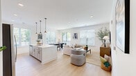 This single-floor residence at 1009 Reagans Rd in Frederick, Maryland offers a thoughtfully designed open-concept layout that seamlessly connects the kitchen, dining, and living areas into one bright, cohesive space. Light hardwood flooring flows throughout, complementing the clean white walls and recessed lighting that give the home a fresh, modern feel.

The kitchen is a standout feature, boasting white shaker cabinetry with matte black hardware, a large center island with pendant lighting, and crisp white quartz countertops. Ample storage and a dedicated pantry area add to the kitchen's functionality. The dining area sits adjacent to a sliding glass door leading to an outdoor balcony, filling the space with natural light and garden views.

The living area is generously sized, with multiple windows fitted with white blinds that allow for both brightness and privacy. A secondary sitting room provides flexible living space.

The bedrooms are calm and well-proportioned, each with large windows and hardwood flooring. The primary bedroom includes a walk-in closet outfitted with wire shelving systems for organized storage. The primary bathroom features a tiled walk-in shower with glass enclosure. A stacked laundry area is conveniently located within the unit. The home's overall palette of whites and natural wood tones creates a light, airy ambiance throughout.