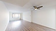 This thoughtfully designed 1-bedroom, 1-bathroom residence offers a comfortable and functional single-floor layout. The spacious living room is a standout feature, showcasing warm hardwood-style flooring, crisp white walls, and a sleek ceiling fan with integrated lighting. A large window floods the space with natural light, creating an open and airy atmosphere. The layout flows seamlessly from the living area toward the kitchen and private quarters via a connecting hallway.

The kitchen is well-equipped with bright white shaker-style cabinetry, granite-look countertops, a stainless steel double-basin sink, and a dishwasher. A window above the sink adds additional natural light to the workspace.

The bedroom is generously sized, featuring the same hardwood-style flooring, a ceiling fan, and a window that brings in natural light. A dedicated closet provides convenient storage. The hallway connects the main living spaces efficiently and includes access to the full bathroom.

The bathroom is clean and functional, appointed with tile flooring, a single-sink vanity with white cabinetry, a large mirror, and a bathtub. The overall design of the residence is characterized by its neutral color palette, consistent flooring, and bright, uncluttered aesthetic throughout.