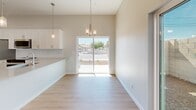 Located at 4630 N 23rd Ave in Phoenix, AZ, this two-story home offers 3 bedrooms and 3 bathrooms thoughtfully distributed across two floors. The main level houses an open-concept kitchen and dining area, featuring crisp white shaker cabinetry, stainless steel appliances including a French door refrigerator, electric range, and over-the-range microwave, all set above light wood-look flooring. The dining area is bathed in natural light from a large sliding glass door that opens to outdoor views, complemented by an elegant chandelier overhead. An attached garage with an automatic opener provides convenient parking and additional storage. The bathrooms are clean and modern, with white vanities, brushed nickel fixtures, and light wood flooring. The upper level is home to the bedrooms, each equipped with ceiling fans, natural light from sliding or standard windows, and light wood-look flooring. The spacious primary bedroom features vaulted ceilings, a sliding glass door leading to a private outdoor area, and a generous walk-in closet with built-in shelving and hanging rods. The additional bedrooms offer bright, airy spaces with neighborhood views. The home's neutral palette and consistent finishes create a cohesive, move-in ready feel throughout.