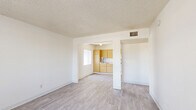 Located at 4401 E 29th St in Tucson, Arizona, this one-bedroom, one-bathroom residence offers a practical and efficient single-floor layout. The living room provides an open, airy feel with light wood-style flooring and a textured ceiling, flowing seamlessly into the kitchen through a wide archway. The kitchen is well-equipped with warm honey-toned wood cabinetry, white appliances including a refrigerator, electric range, microwave, and dishwasher, along with a single-basin sink and ample counter space. A hallway connects the main living areas to the private bedroom, which features the same light wood-style flooring, a window with vertical blinds that admits natural light, and direct access to a generously sized closet with dual hanging rods and built-in shelving. The bathroom includes a full tub-shower combination with chrome fixtures and towel bars. Throughout the unit, clean white walls and consistent flooring create a bright, cohesive atmosphere. The straightforward layout and functional design make this a practical Tucson residence.