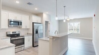Located at 124 Center Church Road in Sanford, NC, this single-floor residence offers a thoughtfully designed layout that maximizes comfort and functionality. The open-concept kitchen and living area serves as the heart of the home, featuring light wood-style flooring, recessed lighting, and a ceiling fan that keeps the space bright and airy. The kitchen is outfitted with crisp white shaker cabinets, granite countertops, a classic subway tile backsplash, stainless steel appliances, and a central island with pendant lighting and an integrated sink — ideal for both cooking and casual dining. Large windows in the living area invite natural light and offer views of the surrounding greenery. The bedroom is a comfortable retreat with plush carpet, two large windows framing outdoor tree views, a ceiling fan, and the notable convenience of two dedicated closets providing generous storage. The bathroom features a wide double-sink vanity with granite countertops, white cabinetry, and wood-style flooring. Additional practical spaces include a pantry, laundry area, utility room, hallway, and a third closet, ensuring storage is never a concern. The overall aesthetic is clean, modern, and move-in ready.