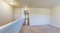 Located at 13024 N Palomino Ln in Spokane, Washington, this two-story home offers a well-organized layout across two generously sized floors, providing ample space for comfortable living. The main level features an open-concept design combining the living room, dining room, and kitchen into a cohesive, light-filled common area. Warm hardwood-style flooring anchors this level, complemented by recessed lighting and a neutral color palette that creates a bright, welcoming ambiance. The kitchen includes a peninsula with counter seating, ideal for casual dining or entertaining.

The upper floor hosts the four bedrooms, connected by well-lit hallways with carpet flooring throughout. The primary bedroom is a comfortable retreat with access to a spacious en-suite bathroom featuring dual sinks with rich dark wood cabinetry, tile flooring, and a walk-in closet outfitted with wire shelving systems for organized storage. The additional bedrooms are carpeted and naturally lit through windows with views of the surrounding greenery. A dedicated laundry room on this level adds everyday convenience.

The lower level includes a finished basement space with recessed lighting and carpet, suitable for a recreation or flex room, alongside an unfinished utility and storage area with exposed ceiling joists. The home also includes a utility room, completing a practical and versatile floor plan.