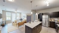 Located at 606 SW 29th Ave in Cape Coral, FL, this single-floor residence offers a thoughtfully designed layout with 2 bedrooms, 2 bathrooms, a dedicated laundry room, and a walk-in closet. The open-concept kitchen and living area serves as the heart of the home, anchored by a large center island with granite countertops, dark cabinetry, pendant lighting, and stainless steel appliances. Light wood-style flooring extends throughout the main living areas, enhancing the bright, airy atmosphere. The living room features large windows and a glass door that invite abundant natural light and connect the interior to the outdoors, complemented by a ceiling fan overhead. Both bedrooms are carpeted and generously proportioned, with the spacious primary bedroom offering room for a full suite of furnishings. The second bedroom benefits from large windows with outdoor views. The bathrooms mirror the kitchen's design aesthetic, featuring granite-topped vanities and dark cabinetry. A dedicated laundry room houses a full-size side-by-side washer and dryer. The walk-in closet provides wire shelving and hanging space for ample storage. Overall, the residence presents a cohesive, modern coastal ambiance throughout.