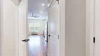 This efficiently designed single-floor unit offers a thoughtfully arranged layout that maximizes every square foot. Warm wood-look flooring runs continuously throughout the space, creating a cohesive and inviting atmosphere from entry to living area. Neutral, light-toned walls and recessed lighting contribute to a bright, airy feel, while a ceiling fan in the main living area enhances comfort year-round. A window with blinds allows natural light to fill the open living space, which is versatile enough to accommodate a variety of furniture configurations.

The kitchen is a standout feature, outfitted with crisp white shaker-style cabinetry, clean white countertops, and a classic subway tile backsplash. A full suite of stainless steel appliances — including a refrigerator, range, over-the-range microwave, and dishwasher — provides modern functionality. The single-basin sink with a brushed nickel faucet completes the well-appointed kitchen.

The bathroom is cleanly finished with the same wood-look flooring, featuring a full tub-shower combination with brushed nickel fixtures, a toilet, and a vanity. The overall design of this unit emphasizes clean lines, modern finishes, and practical use of space, making it a well-rounded and move-in-ready living environment.