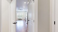 This efficiently designed single-floor unit offers a thoughtfully arranged layout that maximizes every square foot. Warm wood-look flooring runs continuously throughout the space, creating a cohesive and inviting atmosphere from entry to living area. Neutral, light-toned walls and recessed lighting contribute to a bright, airy feel, while a ceiling fan in the main living area enhances comfort year-round. A window with blinds allows natural light to fill the open living space, which is versatile enough to accommodate a variety of furniture configurations.

The kitchen is a standout feature, outfitted with crisp white shaker-style cabinetry, clean white countertops, and a classic subway tile backsplash. A full suite of stainless steel appliances — including a refrigerator, range, over-the-range microwave, and dishwasher — provides modern functionality. The single-basin sink with a brushed nickel faucet completes the well-appointed kitchen.

The bathroom is cleanly finished with the same wood-look flooring, featuring a full tub-shower combination with brushed nickel fixtures, a toilet, and a vanity. The overall design of this unit emphasizes clean lines, modern finishes, and practical use of space, making it a well-rounded and move-in-ready living environment.