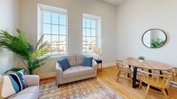 This well-designed two-bedroom, one-bathroom unit on Mason Street in Fall River, Massachusetts, makes efficient use of its single-floor layout. The living room serves as the heart of the space, distinguished by tall ceilings, warm hardwood flooring, and a pair of large double-hung windows that frame neighborhood views and flood the room with abundant natural light. The neutral, light-toned walls enhance the open, airy feel throughout.

The galley-style kitchen is thoughtfully appointed with white shaker cabinetry, granite countertops, a stainless steel sink, and stainless steel appliances including an electric range and built-in microwave. Hardwood floors continue seamlessly from the living area into the kitchen, reinforcing a cohesive aesthetic. A hallway connects the main living spaces to the private quarters.

The primary bedroom is a cozy, well-proportioned room with hardwood floors, neutral walls, and a wall-mounted HVAC unit for climate control. The second bedroom mirrors the clean, minimal style of the rest of the unit. The bathroom features a tub-shower combination with sleek sliding glass doors and a clean, all-white finish. Overall, the unit offers a modern, functional living environment with consistent finishes throughout.