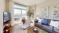 Located at 300 South Carriage Way in London, Ontario, this well-appointed 2-bedroom, 2-bathroom unit offers a thoughtfully designed single-floor layout with a comfortable and modern feel throughout. Light wood-look flooring flows through the main living areas, complementing the warm, neutral palette that unifies the space.

The open-concept kitchen and living area serves as the heart of the unit. The kitchen features crisp white cabinetry, a white marble-style quartz countertop, a subway tile backsplash, stainless steel appliances, and a generously sized island with seating — ideal for both meal prep and casual dining. The adjoining living room is bright and welcoming, highlighted by large sliding glass doors that open to a private balcony and flood the room with natural light.

The spacious primary bedroom features a large window with sheer curtains, allowing soft natural light and outdoor views. The second bedroom is equally comfortable, also benefiting from natural light. Each bathroom is finished with clean, contemporary fixtures — one includes a soaker tub and shower combination, while the other offers a walk-in glass shower. Both feature light wood flooring, white vanities, and understated décor.

A dedicated in-suite laundry room with a stacked washer and dryer adds everyday convenience to this well-rounded home.