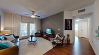 Located at 17203 NW Military Hwy in San Antonio, Texas, this single-story residence offers a thoughtfully designed open-concept floor plan that seamlessly connects the living, dining, and kitchen areas. Rich hardwood flooring flows throughout the main living spaces, creating a warm and cohesive aesthetic.

The living room is a standout feature, highlighted by a bold charcoal accent wall, a ceiling fan with light fixture, and French doors that open to a private balcony, filling the space with natural light. The kitchen is equipped with dark espresso cabinetry, granite countertops, a mosaic tile backsplash, and black appliances, complemented by a cozy built-in banquette dining nook.

The primary bedroom offers plush carpeting, a ceiling fan, and a large window with outdoor views, while a second bedroom provides additional flexibility with its own window and closet. The bathroom features dark wood vanity cabinetry, a white countertop, wood-look flooring, and a tiled tub-shower combination. Throughout the residence, clean white walls and neutral tones create a bright, inviting ambiance that is both functional and stylish.