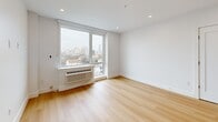 Located on the fifth floor at 337-339 Johnston Ave in Jersey City, NJ, this thoughtfully designed one-bedroom, one-bathroom residence offers a clean, modern aesthetic with high-quality finishes throughout. Light wood flooring flows seamlessly across the entire unit, enhancing the bright and airy atmosphere created by large windows that frame sweeping views of the Jersey City and downtown skyline.

The open-concept kitchen and living area serves as the heart of the home. The kitchen is outfitted with white shaker cabinetry, a subway tile backsplash, stainless steel appliances including a gas range, microwave, and dishwasher, and a central island topped with a stunning marble-look quartz countertop. Globe pendant lights in brushed gold add a warm, stylish touch above the island.

The bedroom is a well-proportioned retreat featuring large windows with city views, recessed lighting, and a double-door closet providing ample storage. A total of three closets throughout the unit ensures excellent organizational flexibility.

The bathroom is finished in crisp white large-format tiles with matte black fixtures, including a vanity with white cabinetry, a framed mirror with overhead lighting, and a soaking tub with a glass partition. An in-unit laundry area adds everyday convenience, rounding out this well-appointed urban residence.
