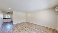 Located at 12360 Riverside Drive in the Valley Village neighborhood of Los Angeles, this one-bedroom, one-bathroom unit offers a well-designed single-floor layout. Light-toned wood flooring runs throughout, complementing crisp white walls and clean baseboards to create a bright, cohesive aesthetic.

The combined kitchen and living area forms the heart of the unit. The kitchen is well-appointed with white shaker cabinetry, dark countertops, a white subway tile backsplash, and a full suite of stainless steel appliances including a refrigerator, range, microwave, and dishwasher. A window with blinds brings in natural light, and a ceiling fan adds comfort. The adjacent living area offers open, flexible space with recessed lighting and a large front-facing window.

The bedroom is a comfortable, well-proportioned room featuring a ceiling fan with light, a wall-mounted HVAC unit, a wide window with natural light, and a full-width mirrored sliding closet that enhances the sense of space.

The bathroom is finished with large-format gray tile in the shower/tub surround, a built-in niche, brushed nickel fixtures, and white cabinetry with a gray countertop. A hallway connects the main living areas, completing the functional floor plan.