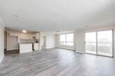 Located at 57 Queen St N in the heart of Kitchener, Ontario, this well-appointed 2-bedroom, 2-bathroom unit offers a thoughtfully designed single-floor layout. Warm hardwood-style flooring flows throughout, complementing a neutral, light colour palette that enhances the bright and airy feel of the space.

The open-concept kitchen is a standout feature, equipped with crisp white shaker cabinetry, grey quartz-style countertops, a subway tile backsplash, stainless steel appliances including a range, microwave, and dishwasher, and a peninsula island ideal for casual dining or meal prep. The kitchen connects seamlessly to the living area, which is generously sized and bathed in natural light through large sliding glass doors leading to a private balcony with open city views.

Both bedrooms are comfortably sized with large windows framing urban views. The primary bedroom includes a dedicated closet with sliding doors. The bathrooms are cleanly finished, with one featuring a full soaker tub surrounded by classic white subway tile and brushed nickel fixtures.

Additional highlights include a dedicated in-unit laundry room with full-sized washer and dryer, a welcoming entrance corridor, and crown moulding details in the living area. The overall ambiance is clean, modern, and move-in ready.