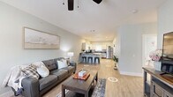 Located at 1933 Argo Rd in Conroe, TX, this single-story, 2-bedroom, 2-bathroom home offers a thoughtfully designed layout with modern finishes throughout. The open living room features light wood-look flooring, soft sage-green walls, a ceiling fan, and natural light from a window with draping curtains — creating a bright and welcoming atmosphere. The kitchen is a standout feature, showcasing crisp white shaker-style cabinetry, dark granite countertops, a light blue backsplash, and a full suite of stainless steel appliances including a gas range, refrigerator, dishwasher, and microwave. Both bedrooms are carpeted and finished with the same cool-toned paint palette, each equipped with a ceiling fan and window for natural light. The primary bedroom includes a closet and comfortable proportions for a full bedroom setup. The two bathrooms mirror the home's refined aesthetic, featuring white vanity cabinetry, dark granite countertops, large mirrors, and wood-look tile flooring. One bathroom includes a tub-shower combination. Clean lines, consistent finishes, and a cohesive neutral color scheme give this home a polished, move-in-ready appeal throughout.