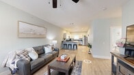 Located at 1933 Argo Rd in Conroe, TX, this single-story, 2-bedroom, 2-bathroom home offers a thoughtfully designed layout with modern finishes throughout. The open living room features light wood-look flooring, soft sage-green walls, a ceiling fan, and natural light from a window with draping curtains — creating a bright and welcoming atmosphere. The kitchen is a standout feature, showcasing crisp white shaker-style cabinetry, dark granite countertops, a light blue backsplash, and a full suite of stainless steel appliances including a gas range, refrigerator, dishwasher, and microwave. Both bedrooms are carpeted and finished with the same cool-toned paint palette, each equipped with a ceiling fan and window for natural light. The primary bedroom includes a closet and comfortable proportions for a full bedroom setup. The two bathrooms mirror the home's refined aesthetic, featuring white vanity cabinetry, dark granite countertops, large mirrors, and wood-look tile flooring. One bathroom includes a tub-shower combination. Clean lines, consistent finishes, and a cohesive neutral color scheme give this home a polished, move-in-ready appeal throughout.