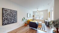This stylish single-floor residence is designed with a cohesive modern aesthetic, combining functionality and visual appeal throughout its open layout. Warm hardwood-style flooring flows seamlessly from room to room, creating a unified and inviting atmosphere.

The kitchen is a standout feature, equipped with stainless steel appliances, a bold two-tone cabinet design pairing crisp white lower cabinetry with deep navy upper cabinets, and a decorative tile backsplash. A white waterfall-edge island with an undermount sink and a matte black faucet provides ample prep space and bar seating for three, illuminated by a pair of striking black pendant lights with gold interiors.

The living area is bright and airy, benefiting from large windows that invite generous natural light and offer views of the surrounding greenery. A ceiling fan enhances comfort, while the open layout allows for flexible furniture arrangement.

The bedroom is comfortably sized with its own large window, ceiling fan, and direct sight lines to the living area, reinforcing the open feel of the home. A closet provides practical storage.

The bathroom is clean and well-finished, featuring a full soaking tub with shower, large-format tile surround, a wide vanity with dark cabinetry, a quartz countertop, and a generous framed mirror.