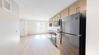 Located at 556 W Lake St in Minneapolis, this 2-bedroom, 1-bathroom unit offers a thoughtfully designed layout with modern finishes throughout. Light wood-toned luxury vinyl flooring runs continuously across the entire space, creating a cohesive and clean aesthetic.

The open-concept kitchen and living area form the heart of the unit. The kitchen features warm maple-toned cabinetry with matte black hardware, white countertops, a double-basin sink, and a full suite of black stainless steel appliances including a refrigerator, electric range, over-the-range microwave, and dishwasher. Ample upper and lower cabinet storage maximizes functionality. The adjacent living area benefits from a large window that brings in generous natural light.

Both bedrooms are well-proportioned with neutral-toned walls, light wood flooring, and closet access. The primary bedroom includes a window with outdoor views, allowing natural light to fill the room.

The full bathroom is finished with large-format light tile flooring, a tub/shower combination with white tile surround, a toilet, and a wood-toned vanity with white countertop and matte black hardware, complemented by a mirror above.

The overall design is clean and contemporary, with a neutral palette that creates a bright, functional living environment.