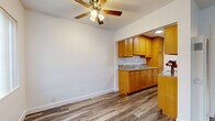 Located at 12618 Lakewood Blvd in Downey, CA, this efficiently designed 2-bedroom, 1-bathroom single-floor unit makes smart use of its compact footprint. Wood-look flooring flows consistently throughout the space, lending a cohesive and modern feel to every room.

The combined living and dining area greets you at entry, featuring ceiling fans with light fixtures and multiple windows dressed with vertical blinds that allow natural light to filter in. The space is open and clean, with crisp white walls and a neutral palette throughout.

The kitchen is well-appointed with warm honey-toned wood cabinetry, granite-look countertops, and a built-in sink. A pantry provides additional storage, keeping the kitchen organized and functional.

The primary bedroom offers a ceiling fan, mirrored sliding closet doors, and light wood flooring, creating a bright and practical retreat. The second bedroom is similarly finished with light wood flooring and a window, offering a clean, versatile space.

The bathroom is neatly appointed with a pedestal sink, full-size soaking tub, and floor-to-ceiling beige tile surrounding the tub/shower combo, complemented by wood-look flooring. A medicine cabinet mirror completes the space. Overall, this unit presents a well-maintained and functional layout suited for efficient everyday living.