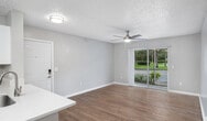 This single-story residence in Port Saint Lucie, Florida, offers 860 square feet of efficiently designed living space. The home features three bedrooms, including a primary bedroom of 170 square feet, and two full bathrooms. The modern kitchen is a highlight, boasting white cabinetry, stainless steel appliances, and a convenient layout with ample counter space. Throughout the home, warm-toned wood-look flooring creates a cohesive and inviting atmosphere. The living areas are bright and airy, with large windows allowing natural light to flood the space. Bedrooms are comfortably sized, with the primary bedroom offering a walk-in closet with wire shelving. Bathrooms are updated with contemporary fixtures and finishes, including a spacious vanity in the main bathroom. The property's neutral color palette and clean lines contribute to its modern aesthetic, while practical features like ceiling fans enhance comfort. This well-maintained home provides a perfect balance of functionality and style in a compact footprint.
