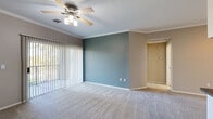 This single-floor residence in Antioch, California offers a thoughtfully designed layout with a neutral color palette and a blend of carpet and wood-look flooring throughout. The spacious living area is highlighted by crown molding, a ceiling fan with light fixture, and vertical blinds covering a sliding glass door that opens to a private balcony, allowing generous natural light to fill the room. An accent wall in soft teal adds a subtle pop of color to the living space.

The kitchen is equipped with white cabinetry, dark countertops, and a full suite of stainless steel appliances including a range, over-the-range microwave, and refrigerator. Wood-look flooring in the kitchen transitions seamlessly from the adjacent carpeted areas.

The bedrooms are carpeted and comfortably sized, each featuring ceiling fans and windows that bring in natural light. One bedroom incorporates a teal accent wall, complementing the overall design theme of the home. The bathroom is finished with wood-look tile flooring, a white vanity with ample cabinet storage, a large mirror, and contemporary light fixtures.

A dedicated laundry area houses a full-size washer and dryer, adding everyday convenience. The space presents a clean, move-in ready interior well-suited for comfortable living.