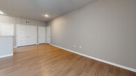 The Juniper floor plan at 5300 Outlook Blvd in Pueblo, Colorado, is a well-designed 2-bedroom, 1-bathroom single-story residence that makes efficient use of its comfortable footprint. Light-toned wood-style flooring runs throughout, creating a cohesive and clean aesthetic from room to room.

The open kitchen is appointed with rich dark-espresso cabinetry, granite-style countertops, a breakfast bar peninsula, and black appliances including a range, microwave, and refrigerator. It flows naturally into the combined living area, which features a ceiling fan, recessed lighting, and a sliding glass door fitted with vertical blinds that provides access to an outdoor patio and brings in natural light.

Both bedrooms are generously proportioned with wood-style flooring, ceiling fans, and windows offering natural light. The primary bedroom includes a dedicated walk-in closet with built-in shelving, while the secondary bedroom also features closet storage. Five-panel interior doors add a modern, clean-lined detail throughout.

The full bathroom is finished with dark wood vanity cabinetry, granite-style countertops, a large mirror, and contemporary lighting fixtures, complemented by tile-style flooring. A hallway connects all rooms efficiently, rounding out this practical and stylish single-floor layout.