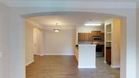 Located at 3801 Glen Verde in Raleigh, North Carolina, this single-story home offers a well-designed layout with a thoughtful blend of comfort and functionality. The open-concept living and dining area is anchored by wood-look flooring, crown molding, a ceiling fan, and a decorative fireplace with a tiled surround, creating a warm and inviting atmosphere. A built-in desk nook adds a practical workspace within the living area. The space transitions seamlessly through an elegant arched entryway into the kitchen, which features warm wood cabinetry, dark countertops, stainless steel appliances including a microwave and range, and a peninsula that serves as both a prep area and casual dining space. The bedrooms are carpeted and filled with natural light through large windows that overlook lush greenery. The primary bedroom includes a walk-in closet and direct access to a private bathroom. The bathrooms are finished with dark countertop vanities, tile-surround tub-shower combinations, and wood-look flooring, offering a clean and functional design. Throughout, neutral tones and consistent finishes contribute to a cohesive and move-in ready environment.
