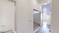 Located at 1100 South Boulevard in Charlotte's vibrant South End neighborhood, this one-bedroom, one-bathroom unit offers a thoughtfully designed layout that maximizes every square foot. The open-concept living, dining, and kitchen area forms the heart of the unit, anchored by a well-appointed galley kitchen featuring rich dark espresso cabinetry, granite-style countertops, a white subway tile backsplash, and a full suite of stainless steel appliances including a refrigerator, electric range, over-the-range microwave, and dishwasher. Light hardwood-style flooring flows throughout the main living areas, lending a warm and cohesive feel. The bedroom is carpeted for comfort and includes a sliding door closet, elevated ceilings that enhance the sense of space, and access to additional storage. The bathroom mirrors the kitchen's design aesthetic with matching dark cabinetry, a granite-top vanity, a large mirror, and a glass-enclosed shower. Practical conveniences include a dedicated pantry, an in-unit laundry area, and a utility room. Natural light filters in through windows in both the kitchen and living areas, brightening the clean, neutral palette throughout. The unit's efficient design and modern finishes make it a functional and stylish urban residence.