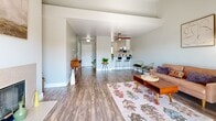 This contemporary 940 square foot apartment in El Sobrante, CA offers a blend of comfort and style. The open-concept living area is the heart of the home, featuring wood-look flooring, a cozy fireplace, and sliding glass doors that lead to a balcony, flooding the space with natural light. The updated kitchen boasts white cabinetry, stainless steel appliances, and a subway tile backsplash, creating a clean and efficient cooking space.

The apartment includes two bedrooms, with the primary bedroom measuring a spacious 150 square feet. Both bedrooms feature plush carpeting and ample natural light. The two bathrooms are modernly appointed with wood-look flooring, white fixtures, and vanities with ample storage space.

Throughout the apartment, neutral tones create a calming atmosphere, while strategically placed windows offer views of the surrounding area. The living room is perfect for entertaining, with space for a dining area and comfortable seating. Thoughtful touches like ceiling fans and modern light fixtures add both functionality and style to this well-designed living space.