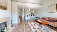 Located at 6000 Sunhill Cir in El Sobrante, CA, this well-appointed 2-bedroom, 2-bathroom residence offers a thoughtfully designed single-level layout. The open-concept living room is a standout, featuring vaulted ceilings, a tiled fireplace, and a sliding glass door that leads to a private balcony with scenic hillside views, flooding the space with natural light. Hardwood-style flooring flows throughout the main living areas, adding warmth and continuity. The kitchen is efficiently designed with white cabinetry, subway tile backsplash, stainless steel appliances including a gas range, microwave, dishwasher, and refrigerator, plus a breakfast bar for casual dining. The living and kitchen areas connect seamlessly, making the layout ideal for everyday living. Both bedrooms are carpeted and feature mirrored sliding closet doors and natural light from well-positioned windows. The primary bedroom offers a comfortable, generously sized retreat. Two full bathrooms include updated vanities with grey countertops and hardwood-style flooring. Additional highlights include four closets, a utility room, hallway, and ample storage throughout.