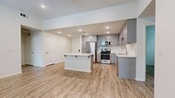 Located at 3000 Van Buren Blvd in Riverside, CA, this single-story, 3-bedroom, 2-bathroom home offers a well-designed layout across a comfortable footprint. Light wood-look flooring flows consistently throughout the entire home, creating a cohesive and clean aesthetic.

The open-concept kitchen and living area serves as the heart of the home. The kitchen is outfitted with gray shaker-style cabinetry, white quartz countertops, a classic white subway tile backsplash, and a full suite of stainless steel appliances including a gas range, over-the-range microwave, refrigerator, and dishwasher. A central island with bar seating adds additional workspace and casual dining potential. The adjoining living area receives natural light through a row of windows fitted with white blinds.

The three bedrooms are bright and neutral, each featuring light-toned walls and natural light from windows with blinds. The generously sized primary bedroom includes a walk-in closet with built-in shelving and hanging rods. The two bathrooms maintain the home's clean, modern style, with one featuring a full tub-shower combo with white tile surround and brushed nickel fixtures. Two hallways connect the home's rooms efficiently. The overall ambiance is fresh, modern, and move-in ready.