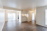 Located at 3843 Penbrook St in Odessa, Texas, this single-floor unit offers a practical and well-organized layout designed for comfortable everyday living. The living area is a standout feature, showcasing rich, dark hardwood-style flooring that extends throughout the main living spaces. Large sliding glass doors flood the room with natural light and provide direct access to an outdoor patio, creating a seamless indoor-outdoor connection.

The kitchen is conveniently positioned adjacent to the living area, accessible via a pass-through opening that enhances the open feel of the space. It features white cabinetry, granite-look countertops, and a coil-top electric range with an overhead ventilation hood, providing all the essentials for meal preparation.

The bedrooms offer a contrast in flooring, with plush carpeting underfoot for added comfort. Each room benefits from natural light courtesy of large windows dressed with vertical blinds. The bathroom includes a vanity with a mirror, white cabinetry, and a bathtub-shower combination, maintaining the clean and neutral aesthetic found throughout the unit.

Overall, the space is characterized by a neutral color palette of crisp whites and warm beige tones, creating a bright and inviting atmosphere that is move-in ready and easy to personalize.
