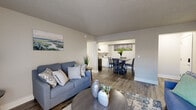 Located at 870 Chapman Dr in Colorado Springs, CO, this single-floor residence offers a well-organized and cohesive interior design with a neutral, contemporary aesthetic throughout. The entryway greets visitors with clean white paneled doors, wood-look flooring, and textured walls that set the tone for the rest of the home.

The open-concept living area flows naturally into the dining and kitchen spaces. The living room accommodates comfortable seating arrangements and is brightened by a window dressed with layered blinds and sheer curtains. Wood-look plank flooring and a textured ceiling are consistent across the main living spaces.

The kitchen features white shaker-style cabinetry, granite-look countertops, black appliances including a range and stainless steel refrigerator, and a stainless undermount sink — offering a functional and updated workspace. The adjacent dining area provides space for a full table and chairs.

Two bedrooms are present, each finished with wood-look flooring, textured ceilings, and neutral wall tones. Both rooms offer adequate space for bedroom furniture and storage. The bathroom is appointed with a granite-topped vanity, wood-look flooring, and clean white finishes, maintaining the home's consistent style.

Overall, the space presents a clean, move-in-ready interior with cohesive finishes and practical layout throughout.