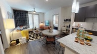 Located in Dallas, Texas, this single-floor residence offers a thoughtfully designed open-concept layout that seamlessly connects the living, dining, and kitchen areas. The living room features wood-look flooring, a ceiling fan, and large windows with floor-to-ceiling drapes that allow for abundant natural light, creating a warm and inviting atmosphere. A spacious sectional sofa and bold geometric-patterned area rug add a contemporary flair to the space.

The kitchen is a standout feature, equipped with dark espresso cabinetry, granite countertops, stainless steel appliances, and a large center island with pendant lighting overhead — ideal for both cooking and casual dining. The adjacent dining area accommodates a round table with mixed-material seating.

The residence includes multiple bedrooms, each carpeted and outfitted with ceiling fans and generous windows that invite natural light and outdoor views. The primary bedroom benefits from a walk-in closet and an en-suite bathroom featuring dual granite vanities, a glass-enclosed shower, a soaking tub, and dark cabinetry. A secondary bathroom mirrors the refined aesthetic with a granite vanity and dark cabinetry. Throughout, the design balances modern functionality with comfortable, contemporary style.