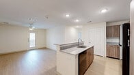 This single-floor residence features 3 bedrooms, 2 bathrooms, and a thoughtfully designed open-concept layout. Light hardwood-style flooring flows consistently throughout the entire home, creating a cohesive and clean aesthetic. The combined kitchen and living area serves as the heart of the home, anchored by a central kitchen island finished with granite countertops, a double undermount sink, and warm wood-tone cabinetry. Recessed lighting and a ceiling fan enhance comfort and functionality in this shared space, which also benefits from natural light via a glass exterior door leading outside. Additional kitchen cabinetry and a refrigerator are visible along the back wall, providing ample storage. The bedrooms are bright and generously proportioned, each equipped with ceiling fans and windows fitted with blinds. Closets are present in the bedrooms, offering practical storage solutions. The primary bathroom features a double-sink vanity with granite countertops, wood-tone cabinetry, and a large mirror, paired with a stunning marble-tiled shower. The secondary bathroom includes a marble-tiled tub and shower combo. Two hallways connect the rooms efficiently, and three closets provide additional storage throughout. The home presents a clean, modern, and move-in-ready interior.