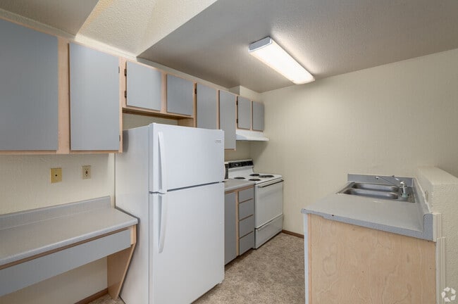 Kitchen with refrigerator, oven, stove, microwave - Cedar Apartments