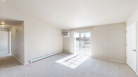 Located at 1001 Karsten Dr in Horicon, WI, this single-floor, 2-bedroom, 2-bathroom home offers a thoughtfully designed layout with a clean, neutral aesthetic throughout. The open-concept kitchen and living area serves as the heart of the home, featuring warm hardwood-style flooring in the kitchen, white shaker cabinetry, light quartz countertops, and a full suite of stainless steel appliances including a refrigerator, range, microwave, and dishwasher. The living room is bright and airy, with plush carpet, a wall-mounted AC unit, a baseboard heating system, and a sliding glass door that opens to an outdoor balcony with exterior views. The primary bedroom is a generous retreat with vaulted ceilings, a ceiling fan, and a mix of carpet and hardwood-style flooring. The second bedroom features plush carpet, a ceiling fan, and natural light from a window. Both bathrooms are finished with white cabinetry, light countertops, hardwood-style flooring, and modern brushed nickel hardware — one featuring a walk-in shower. A dedicated in-unit laundry room with a front-loading washer and dryer and built-in wire shelving adds practical convenience. The hallway connects all spaces efficiently, completing this well-appointed home.