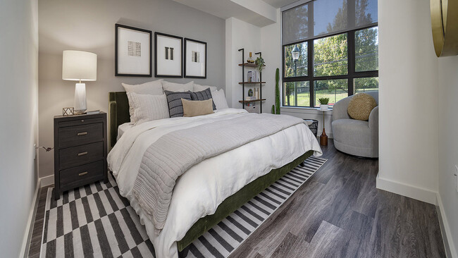 Spacious apartment bedroom with wood-style flooring. - Griffis Edgemoor