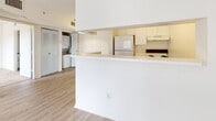 Located at 741 Providence Trace Cir in Brandon, FL, this single-floor residence offers a clean, open layout designed for comfortable everyday living. Light wood-style flooring runs throughout the main living areas, creating a bright and cohesive aesthetic that extends from the living room to the kitchen and beyond.

The living area is generously sized and filled with natural light streaming through a large sliding glass door fitted with vertical blinds. A pass-through counter connects the living space to the kitchen, which features cream-toned cabinetry, a white refrigerator, an electric range, and a range hood — all within a compact and functional footprint.

A dedicated laundry area with stacked washer and dryer units is conveniently tucked nearby, adding practical value to the space. The bedroom offers plush carpeting underfoot, a ceiling fan for year-round comfort, and a window with outdoor views, making it a relaxing retreat. A closet with louvered bifold doors provides ample storage.

The bathroom is well-appointed with a tiled tub-shower combination equipped with a grab bar, a single-sink vanity with cabinet storage beneath, a large mirror, and wood-style flooring that complements the rest of the unit. Overall, the space presents a light, neutral palette that feels clean, functional, and move-in ready.