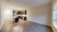 This contemporary 660 square foot apartment offers a thoughtfully designed living space in Philadelphia. The open-concept layout seamlessly integrates the kitchen, dining, and living areas, creating a spacious feel. The kitchen is a standout feature, boasting sleek dark wood cabinetry, stainless steel appliances, and a striking blue island with a white countertop, perfect for casual dining or food preparation.

Light wood-look flooring runs throughout the main living areas, while plush carpeting adds comfort to the bedrooms. The primary bedroom, measuring 140 square feet, provides ample space and features a large window allowing natural light to flood in. A well-appointed bathroom showcases a modern vanity with ample storage and a stylish mirror.

The apartment's design emphasizes functionality with a generously sized closet featuring built-in shelving. Recessed lighting and pendant fixtures add to the contemporary ambiance, while large windows in the living area offer views of the surrounding neighborhood. This single-floor unit combines modern aesthetics with practical living, ideal for those seeking a sleek urban dwelling in the heart of Philadelphia.
