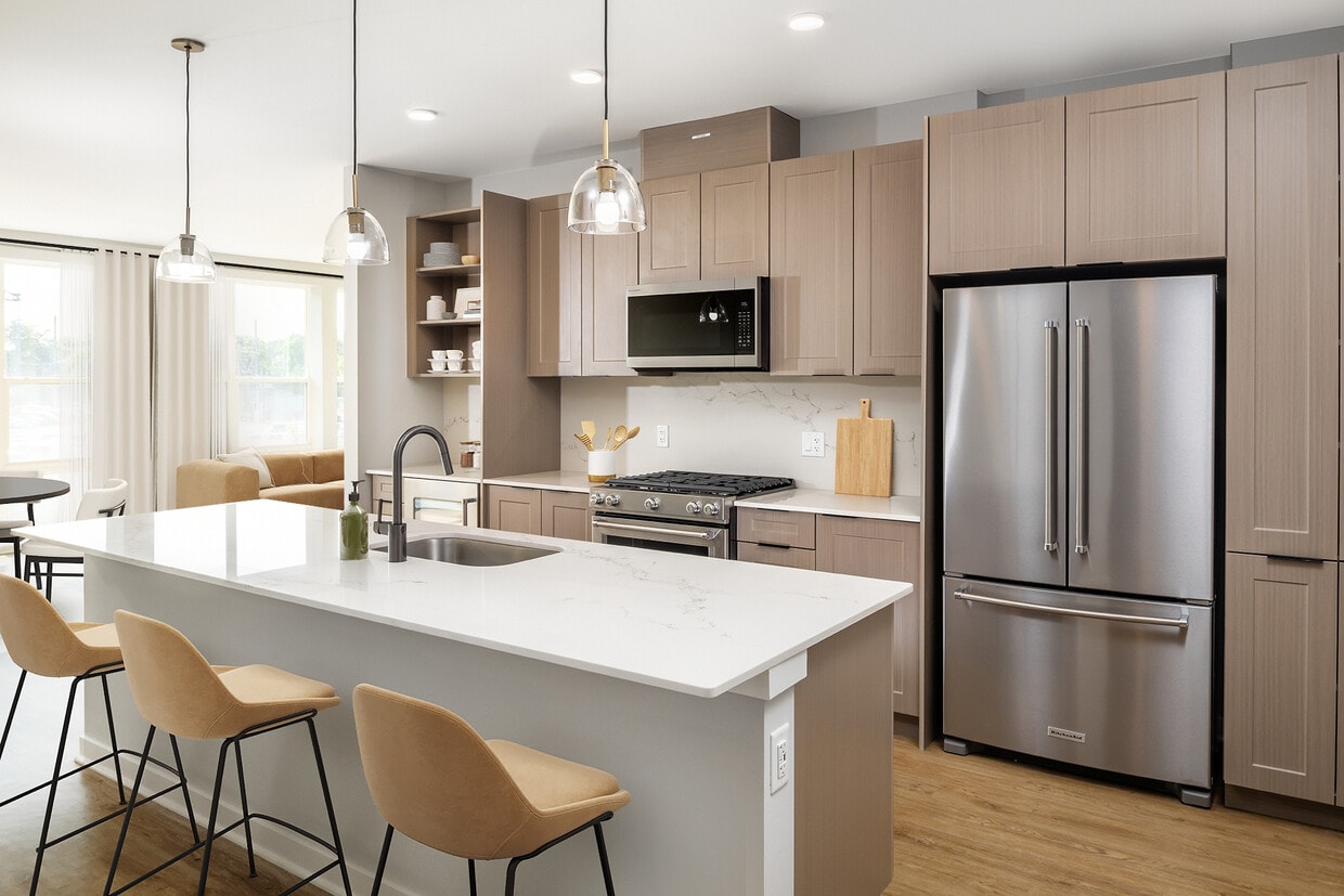 Signature Collection Kitchen with oak shaker cabinetry, marbled white quartz countertop, and upgraded stainless steel appliances - Avalon W Squared