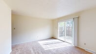 This two-story, 2-bedroom, 2-bathroom home in Indianapolis, IN is thoughtfully laid out across two evenly divided floors. The main level features a light-filled living room with sliding glass doors that open to an outdoor fenced area, flooding the space with natural light and providing easy outdoor access. Adjacent to the living room is a dedicated dining area, connecting seamlessly to the kitchen. The kitchen is equipped with tile flooring, cream cabinetry, a white electric range, and white countertops, with a window above the sink that brings in additional natural light. A pantry and laundry area round out the functional main floor, along with a hallway and bathroom. Upstairs, the two carpeted bedrooms offer comfortable retreats, each with windows that provide natural light and outdoor views. The spacious primary bedroom features generous closet space with built-in shelving. A second well-sized bedroom and an additional bathroom complete the upper level. The bathroom includes a tiled tub-shower combination with marble-style accent tiles and a privacy window. Throughout, the home maintains a neutral, clean palette with multiple closets providing abundant storage across both floors.