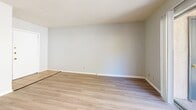 Located at 213 Argonaut Dr in El Paso, Texas, this efficient single-story, one-bedroom, one-bathroom residence offers a well-organized layout across a compact yet functional floor plan. The dual living areas feature light wood-style flooring, textured ceilings, and neutral gray walls that create a clean, airy atmosphere. One living space is bathed in natural light through a large sliding glass door that opens to a private balcony overlooking lush greenery, while a second living area benefits from a wide window framing outdoor views and includes a distinctive arched architectural detail that adds character to the space. The galley-style kitchen is efficiently designed with ample cream cabinetry on both sides, white countertops, tile flooring, a double-basin sink, and full white appliances including an electric range and refrigerator. The bedroom is carpeted for comfort, features a ceiling fan with light fixture, and connects directly to a dedicated walk-in closet complete with built-in shelving. The full bathroom includes tile flooring in warm earth tones, a combined shower and tub, toilet, and vanity. A hallway connects the main living areas to the private spaces, completing this straightforward and practical floor plan.